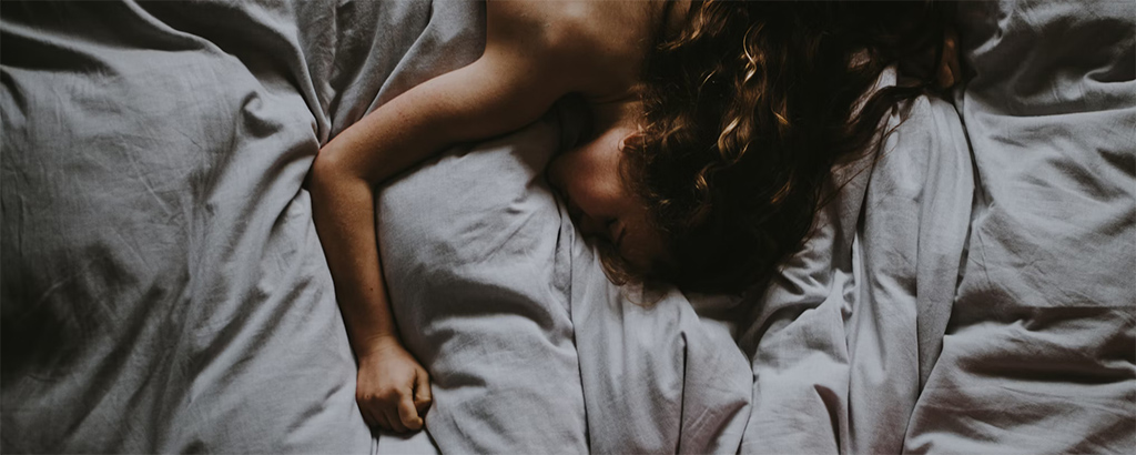 A woman sleeping naked on a bed